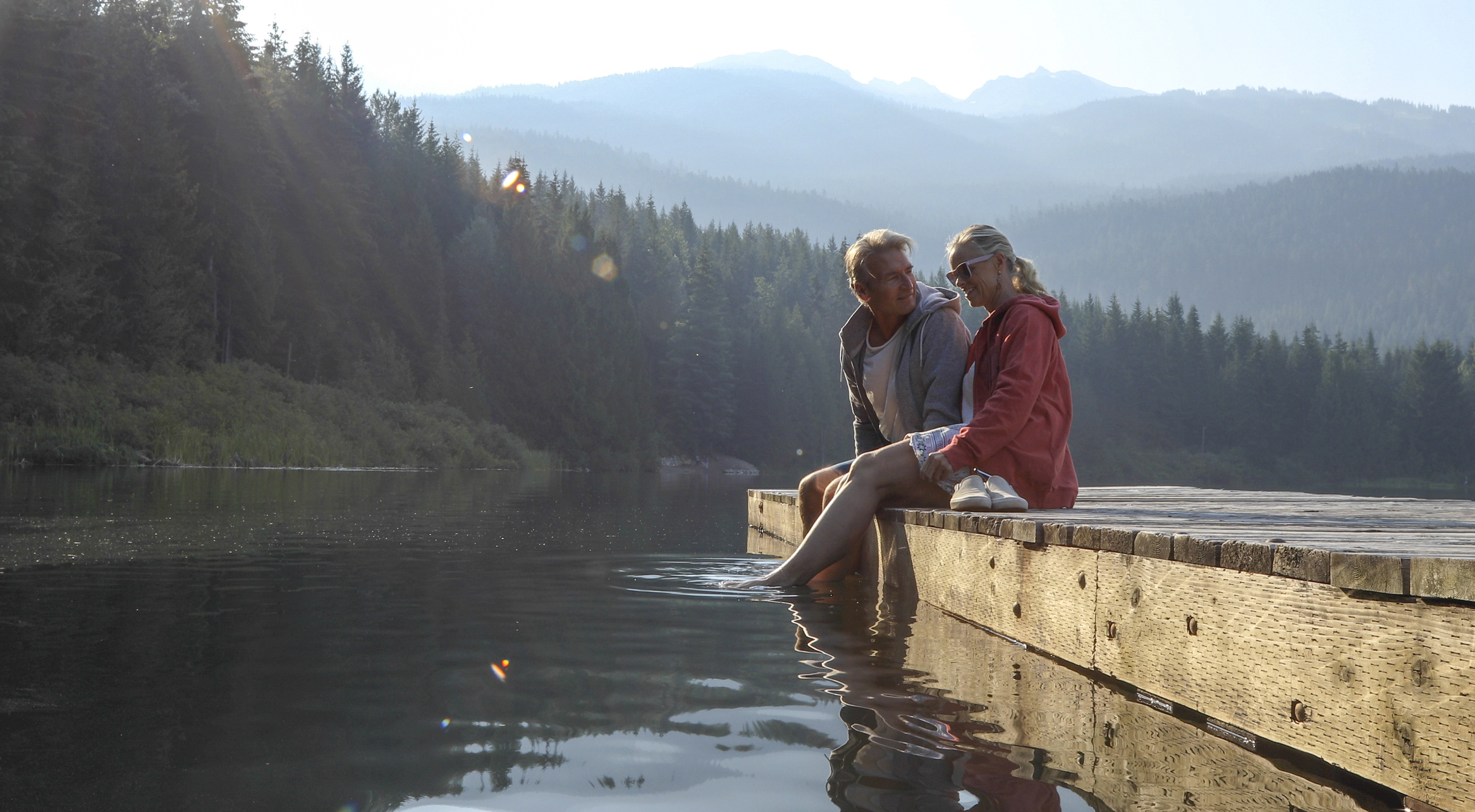 Two people sitting by the lake.