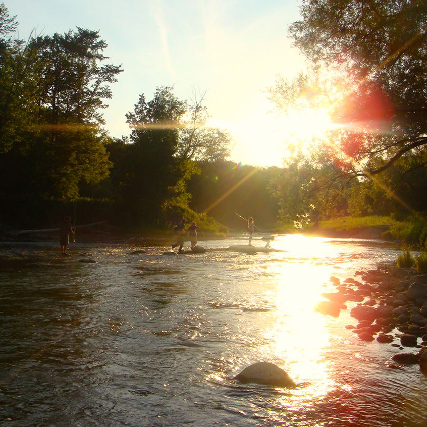 Image of sunlight hallow river and people on rocks